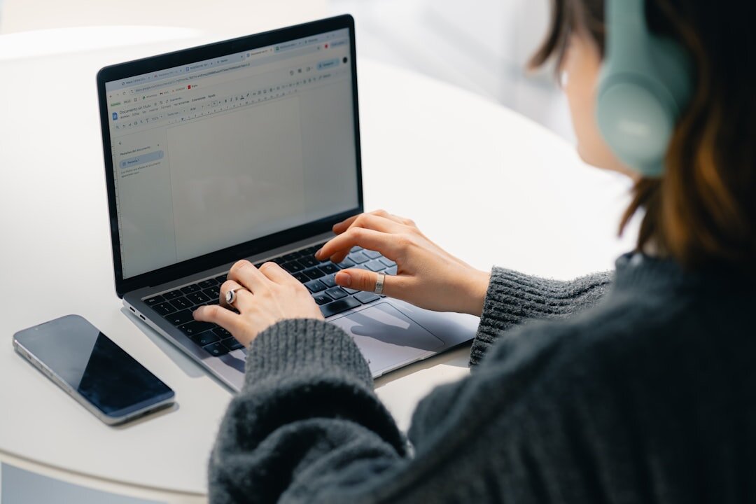 Close-up of hands typing an interview transcript on a laptop